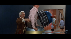 Ian (Roy Castle) aided by Doctor Who (Peter Cushing) climbs into a Dalek casing